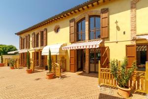 a building with a courtyard with potted plants in front of it at La Corte del Mulino in Fontanellato