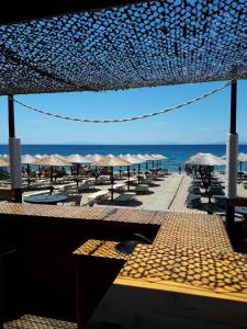a beach with chairs and umbrellas and the ocean at Dina in Palaia Fokaia