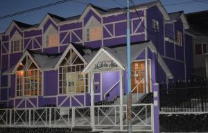 una casa púrpura con un cartel delante en Hostería Ailen en Ushuaia