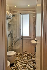 een badkamer met een douche, een toilet en een wastafel bij Family Suite Appartments Orchidea Blu in Rimini