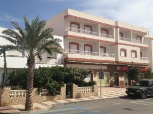 a building with a palm tree in front of it at Apartamentos Sol Andaluz in Carboneras