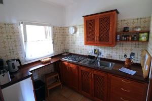 eine Küche mit Holzschränken, einem Waschbecken und einem Fenster in der Unterkunft Apartamentos Miranda in Breña Alta