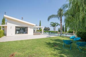 a yard with two chairs and a swimming pool at Oscar Domain Villa in Protaras