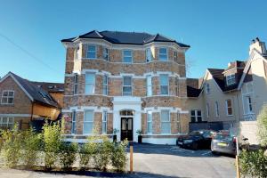 a large brick house with cars parked in front of it at Stunning Luminous Penthouse/ 2Beds 2Baths in Bournemouth