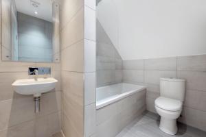 een badkamer met een toilet, een wastafel en een bad bij Stunning Luminous Penthouse/ 2Beds 2Baths in Bournemouth