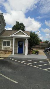 a house with a blue door in a parking lot at InTown Suites Extended Stay Greenville SC -I-85 Mauldin in Greenville
