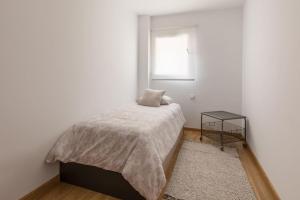 biała sypialnia z łóżkiem i oknem w obiekcie Apartamento La Nuit con Parking gratis en centro histórico w mieście La Laguna