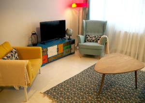 a living room with two chairs and a flat screen tv at Apartamento Casa Palabra in Santander
