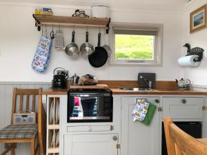 a kitchen with white cabinets and a counter top at Fisherman's Hut in Tarbert