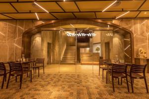 a dining room with tables and chairs and a staircase at Hotel Metropole Inn in Mumbai