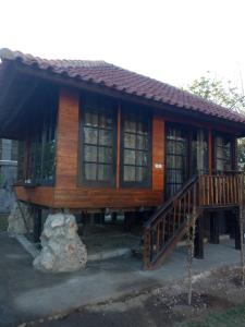 a log cabin with a porch and a staircase in front at Pier26 Bali Homestay in Nusa Dua