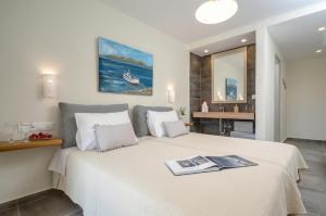 a hotel room with a bed, desk, and a painting on the wall at Hotel Naxos Beach in Naxos Chora