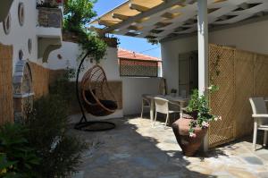 un patio con mesa, sillas y pérgola en Studios Yalos, en Khorevtón