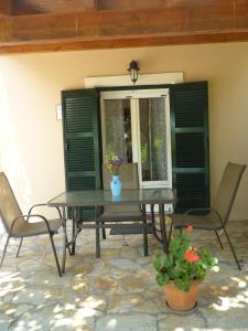 a patio with a table and chairs and a window at Emely Apartments in Gouvia