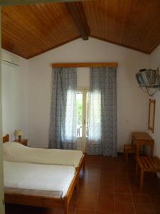 a bedroom with a bed and a window at Emely Apartments in Gouvia