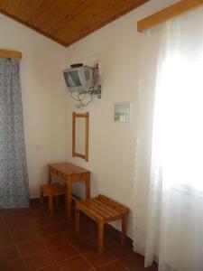 a room with a table and a tv on the wall at Emely Apartments in Gouvia