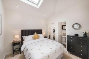 a white bedroom with a bed and a mirror at Beautiful West London House in London
