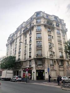 un gran edificio blanco en la esquina de una calle en Confortable 3 pieces, capitale Paris, en Nogent-sur-Marne