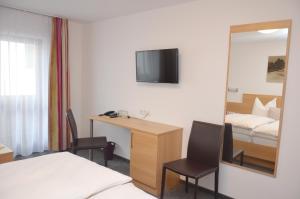 a hotel room with a bed and a desk and a mirror at Hotel Garni Sport Sonneck in Galtür