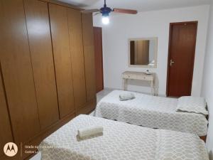 a room with two beds and a cabinet and a mirror at Casa com conforto e segurança in Rio das Ostras