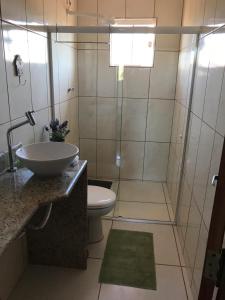 ein Bad mit einem WC, einem Waschbecken und einer Dusche in der Unterkunft Casa com conforto e segurança in Rio das Ostras