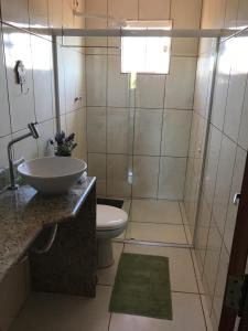 a bathroom with a toilet and a sink and a shower at Casa com conforto e segurança in Rio das Ostras