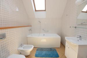 a bathroom with a tub and a toilet and a sink at Naujoji Karkle in Karklė +29 photos
