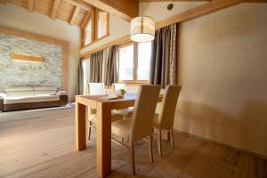 uma sala de jantar com uma mesa de madeira e cadeiras em Chalet Cuna Bela em Livigno