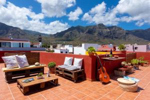 a patio with a guitar on a roof with mountains at Tabaiba Guesthouse in Buenavista del Norte
