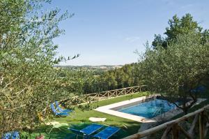 een zwembad met uitzicht op de bomen bij Casale del Monsignore in Spoleto
