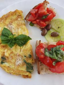 a white plate with two slices of toast and tomatoes at Oasi di Villa Damecuta in Anacapri