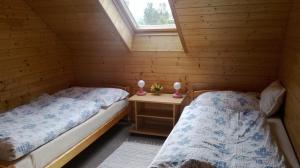 two beds in a log cabin with a window at Chalupa v soukromí Chřibská in Chřibská