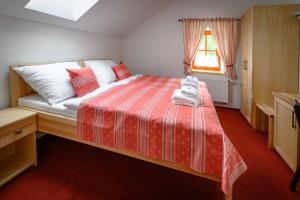 a bedroom with a red and white bed with a window at Venclův statek in Javornice