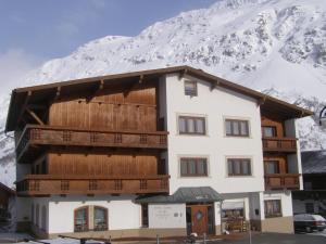 budynek przed pokrytą śniegiem górą w obiekcie Hotel Garni Sport Sonneck w mieście Galtür