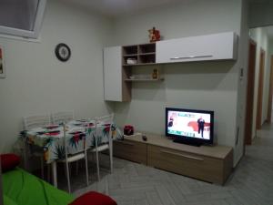 a living room with a dining table and a television at APPARTAMENTO in seminterrato PALMAROLA in Sabaudia