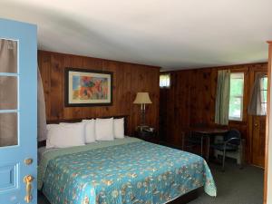 une chambre d'hôtel avec un lit, une table et une fenêtre dans l'établissement Northeaster Motel, à Kittery