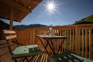 un tavolo e due sedie su una terrazza di legno di Ciasa MAEL Dolomites Apartments a La Valle