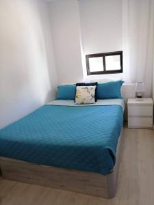 Bett mit blauer Bettwäsche in einem weißen Zimmer in der Unterkunft Sea View 3 in Albufeira