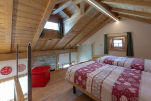 two beds in a room with wooden ceilings at Toilain in Livigno