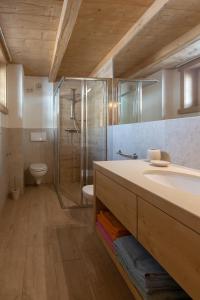 een badkamer met een douche, een wastafel en een toilet bij Toilain in Livigno