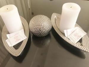 two white candles on a table with a mirror at Hotel Alcazar in Buenos Aires