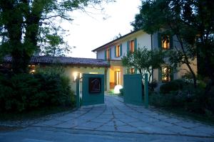 uma casa com um portão verde e uma entrada em La Casa del Giardiniere em Zero Branco