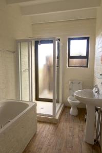 a bathroom with a tub and a toilet and a sink at Phillipskop Mountain Reserve in Stanford