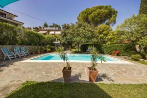 a swimming pool with two potted plants in a yard at Luxury Apartments PORTO, free parking in Portorož