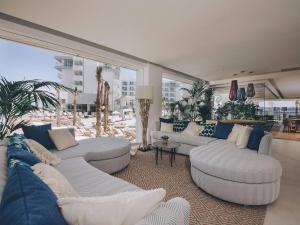a living room filled with furniture and a large window at Amàre Beach Hotel Ibiza Adults Only in San Antonio Bay