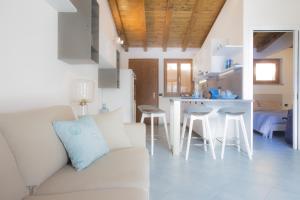 a white living room with a couch and a kitchen at Venere Paolina - Goelba in Marciana