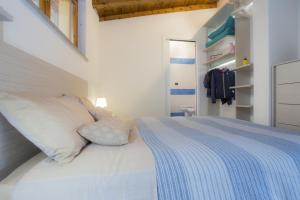 a bedroom with a bed with a blue and white blanket at Venere Paolina - Goelba in Marciana