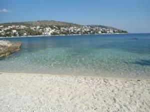 a beach with the water and a city in the background at Apartments Slavica Trogir in Trogir