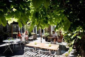 een groep mensen die aan tafel zitten in een tuin bij Fitz Roy Urban Hotel, Bar and Garden in Maastricht