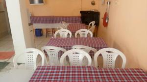 una mesa y sillas en una habitación con una cortina de color rojo y blanco en Hospedaria Praia e Sol, en Fortaleza